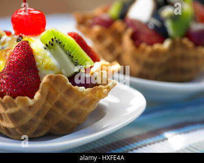 Früchte Eisbecher in Waffel-Korb auf Tisch Stockfoto