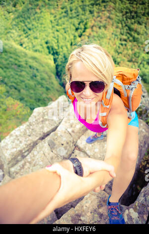 Helfende Hand paar, Wandern helfen sich gegenseitig. Mann und Frau mit Motivation und Inspiration, schöne inspirierende Landschaft wandern oder klettern. Extr Stockfoto