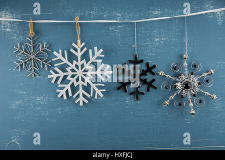 Snowflake Ornamente in absteigender Höhe von weiße Schleife hängen Stockfoto