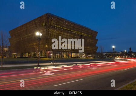 Verkehr schafft Lichtspuren in der Dämmerung außerhalb des Smithsonian National Museum of African American History und Kultur (NMAAHC) in Washington, DC. Stockfoto