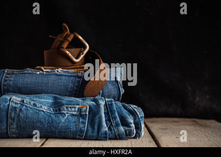 Altes Leder Gürtel und Jeans auf einem Holzboden. Stockfoto