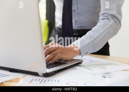 Geschäftsmann ' s Hände analysieren, Diagramme und Grafiken und tippen auf modernen Laptop-Computer im Büro. Business Analyse und Strategie-Konzept. Stockfoto