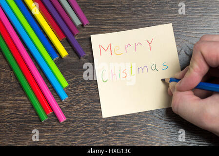 Hand-Schriftzug auf ein Stück Papier auf einem Holztisch. Stockfoto