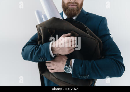 Schuss der junge Geschäftsmann umarmt Tasche mit gerollten Blaupausen beschnitten Stockfoto