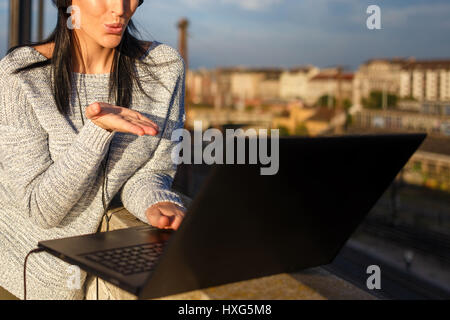 Junge Frau senden Küsse per Laptop im freien Closeup, wireless-Technologie Stockfoto