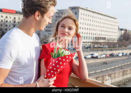 Junger Mann mit Frau im roten Kleid im Freien aus Stockfoto