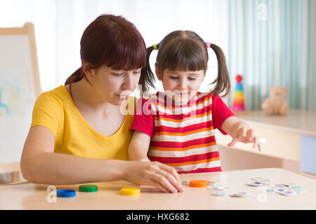 Kind Mädchen und Mutter gemeinsam mit Puzzle Spielzeug spielen Stockfoto