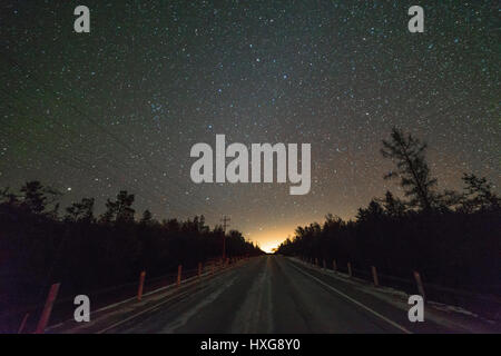 Autobahn 6 im Winter in der Nacht mit Sternen zeigen und Pinien Bäume an den Seiten der Straße. Stockfoto