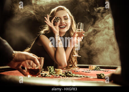 Porträt der lächelnde Frau mit Getränk und Poker chip Poker zu spielen Stockfoto