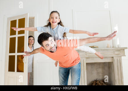 Lächelnde Mutter beobachten wie Vater mit Tochter spielen Stockfoto