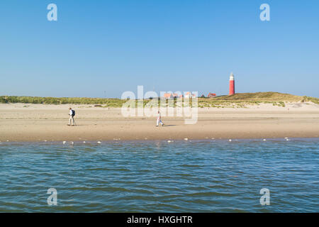 Aktive Rentner zu Fuß am Strand und Leuchtturm von De Cocksdorp auf West friesischen Wattenmeer Insel Texel, Niederlande Stockfoto