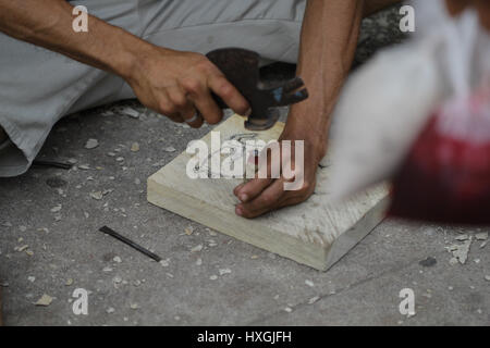 Hände eines Mannes der Begierde und arbeitet auf einem hölzernen plate.making Zubehör konnte er in Handarbeit Markt verkaufen. Stockfoto