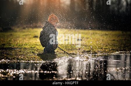 Kleiner Junge spielt im Freien im zeitigen Frühjahr. glückliche Kindheit Stockfoto