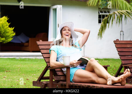 Portrait einer älteren Frau lächelnd mit Buch außerhalb Stockfoto