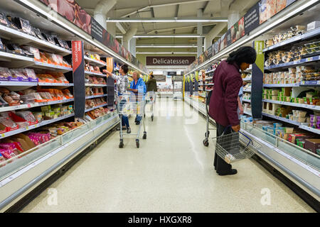 Shopper am Gang in Tesco Supermarkt Lebensmittelhalle, Großbritannien Stockfoto