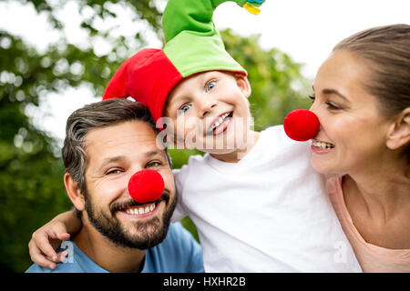 Gut gelaunt und fröhlich Familie mit Kind am Karneval Spaß Stockfoto