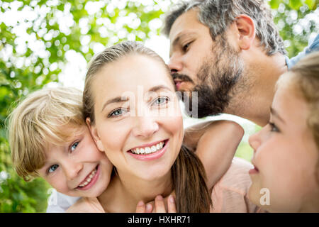 Glückliche Familie verliebt küssen Mutter Vater Stockfoto