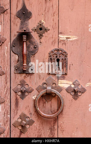 Alte rostige Schleuse, behandeln und in eine hölzerne Tür klingeln. Stockfoto