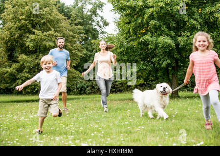Kinder dem Hund spazieren gehen und Spaß haben beim laufen Stockfoto