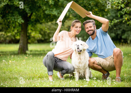 Familie mit Hund und Dach als Heim- oder Gebäude Baukonzept Stockfoto