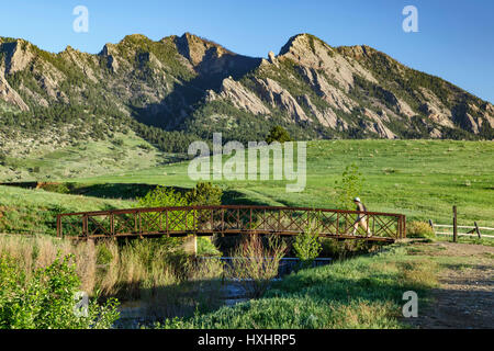 Wanderer gehen über die Brücke, Flatirons im Hintergrund, in Boulder, Colorado, USA Stockfoto