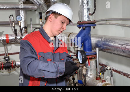 St. Petersburg, Russland - 5. März 2013: Ingenieur Klempner im Prozess Instandhaltung und Reparatur von Heizungsanlagen und Wasserversorgung in der Wohnung b Stockfoto