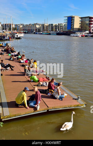 Warmer, sonniger Tag mit Menschen sitzen auf Schwimmdock im Stadtzentrum von Bristol docks Stockfoto