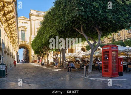 VALLETTA, MALTA - 24. Juli 2015: Die Ansicht der Old Theatre Street mit Café im Freien voll von Menschen in den Sommertag und die rote Telefonzelle. VA Stockfoto