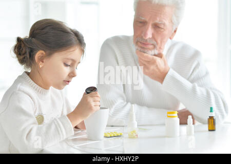 Enkelin kümmert sich um einen kranken Großvater Stockfoto