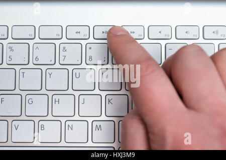 Zeigefinger Pressen die Play Taste auf dem weißen Tastatur, Nahaufnahme, verschwommen Stockfoto