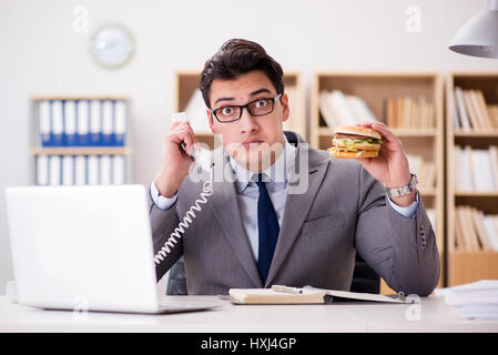 Hungrige lustige Geschäftsmann Essen Junk-Food-sandwich Stockfoto