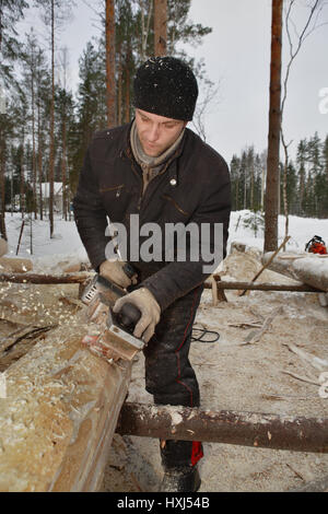 Gebiet Leningrad, Russland - 2. Februar 2010: Sawyer verwendet das Flugzeug um Rinde aus Protokollen zu entfernen. Stockfoto