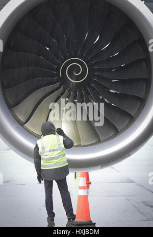 Vancouver, Kanada. 28. März 2017. Ein Flughafen-Boden-Crew-Mitglied inspiziert den Motor von einem Airbus A350-900-Passagier-Jet nach seinen ersten Flug nach Kanada in Vancouver, Kanada, am 28. März 2017 geplant. Ein neuen Airbus A350-900-Passagier-Jet machte seine ersten Linienflug nach Kanada am Dienstag und Cathay Pacific Nutzung des Flugzeugs für die Vancouver-Hong Kong-Route begann. Bildnachweis: Liang Sen/Xinhua/Alamy Live-Nachrichten Stockfoto