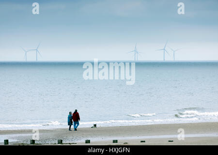 Walker mit einem frühen Morgen Hund Spaziergang Hund am Strand im beliebten touristischen Stadt von Rhyl, Denbighshire, Wales Stockfoto