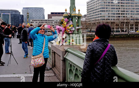 London, UK. 29. März 2017. Leute fangen an, über die Westminster Bridge sammeln heute eine Woche, nachdem Khalid Masood vier Menschen auf der Brücke und in die Häuser von Parlament Ehre getötet: Simon Dack/Alamy Live News Stockfoto