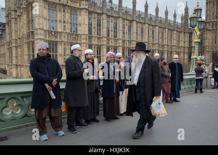 London, UK. 28. März 2017. Londoner und Polizei versammeln sich auf Westminster Bridge, die Szene der Terroranschlag vor 7 Tagen, in denen 4 Menschen starben und andere schwer verletzt, am 29. März 2017, London, England. Hunderte überquert die Themse in eine Stille Mahnwache um denen zu gedenken, die bei 14:40 starb als Khalid Masood in Massen auf der Brücke fuhr vor dem stechen ein Polizist an der nahe gelegenen Palast von Westminster. Die Massen verstummte, viele Verbeugung ihre Köpfe, darunter waren Dutzende von jungen muslimischen Kinder und Mitglieder der Ahmadiyya-Gemeinschaft. © Richard Baker/Alamy Live-Nachrichten Stockfoto