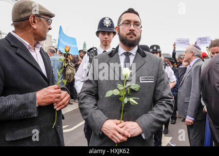 London, UK.  29. März 2017.  Tausende von Menschen versammeln sich auf Westminster Bridge um ihren Respekt für die Opfer des Terroranschlags Westminster vor einer Woche zahlen.  Vertretern der muslimischen Gemeinde und anderen Religionen, in Begleitung von Mitgliedern der Metropolitan Polizei legte Blumen in der Nähe der Houses of Parliament.  Bildnachweis: Stephen Chung / Alamy Live News Stockfoto