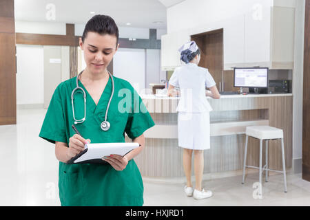 Krankenschwester im Krankenhaus eine Krankenakte schriftlich Stockfoto