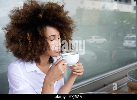 Porträt einer jungen Frau, die Tasse Kaffee hautnah Stockfoto