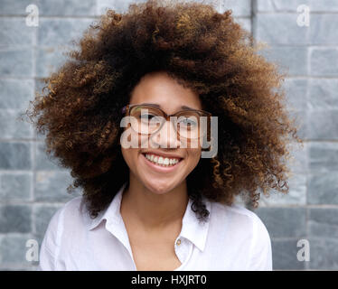 Porträt von lächelnden jungen Afrikanerin mit Afro und Gläser Stockfoto