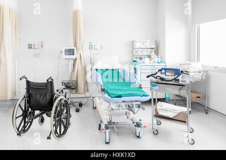 Leeren Rollstuhl im Krankenzimmer mit Betten und komfortabel ausgestattet in einem modernen Krankenhaus medizinische geparkt Stockfoto