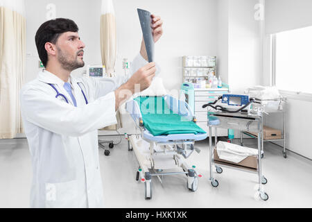 Arzt beobachten Röntgenbild im Krankenzimmer Stockfoto