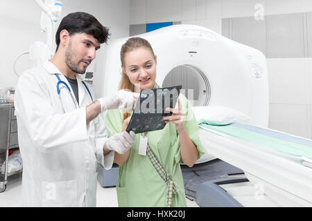 Arzt in CT Untersuchungsraum Untersuchung eine Röntgenaufnahme und diskutieren mit einem Patienten Stockfoto
