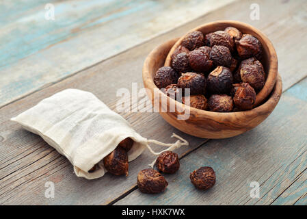 Waschnüsse in Schüssel auf hölzernen Hintergrund closeup Stockfoto