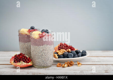 Pudding mit Chia-Samen, Joghurt und frischem Obst in Gläsern auf hellem Hintergrund Stockfoto