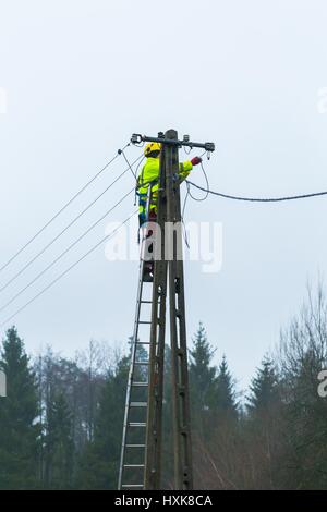 Elektriker arbeiten an Hochspannungsleitungen. Ausfall der Stromleitungen auf Strommast. Stockfoto