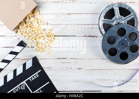 Draufsicht der Filmrollen, Popcorn und Film Klöppel auf Holztisch, Movie Time Konzept Stockfoto