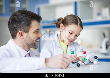 Lehrer und Schüler Wissenschaftler betrachten Molekül Modell im Labor lächelnd Stockfoto