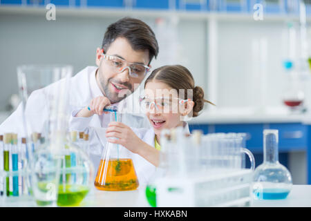 Lehrer und Mädchen Student Wissenschaftler in Schutzbrille macht im Labor experimentieren Stockfoto