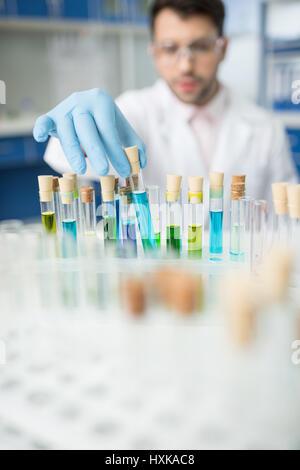 Mann-Wissenschaftler arbeiten mit Glasröhren im Labor Stockfoto